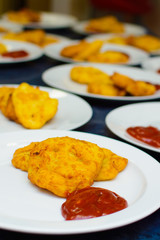 many servings of potato pancakes with ketchup on plates