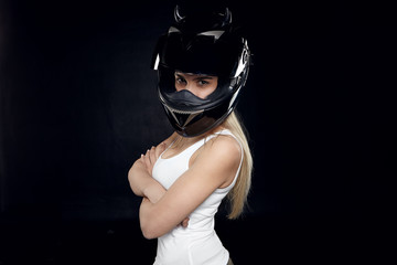 Extreme sports, activity and risk concept. Studio shot of self confident serious young blonde woman rider in protective helmet and tank top keeping arms folded against black copy space wall background