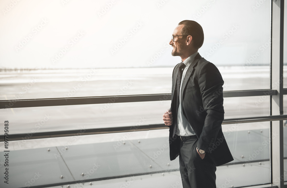 Poster side view profile of contented stylish businessman looking through large window. copy space in left 