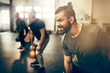 Fit people exercising with weights during a gym class