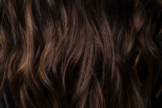 Beautiful curvy dark brown hair with chocolate highlights. I photographed in the beauty salon during the work of the stylist. Stunning texture and wallpaper hair. Hair Background