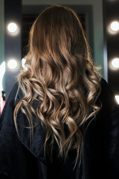 Elegant hair styling. Hair shines and beautifully curled in curls. The final result after the work of the hairdresser. I photographed in the beauty salon