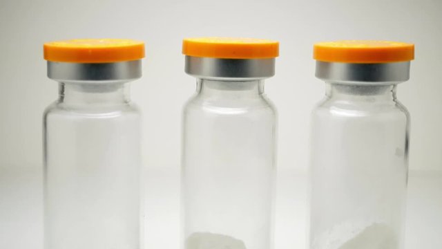 three glass ampoules with white powder. pan