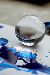 glass bowl and reflection in blue ink puddle. Abstraction.