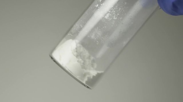 white powder medication inside a glass ampoule. close-up