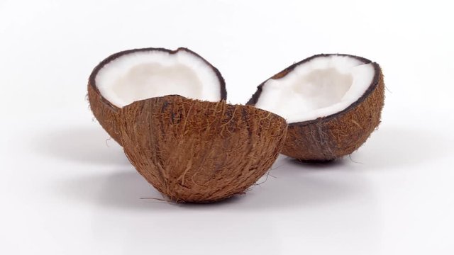 Three ripe tropical coconut halves with yummy white pulp rotating on white isolated background. Healthy fresh tropical fruits. Loopable seamless cocos rotating
