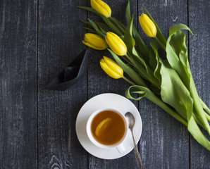 background with black ship, cap of tea and tulips