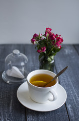 background with cap of tea, roses, paper`s airplane under glass (vertically)