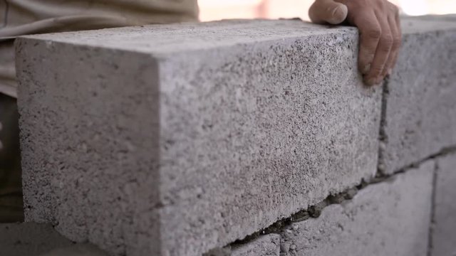 Close up shot of a builder working on a site and bulding a wall.