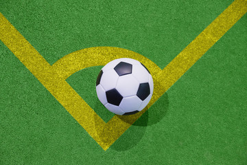 Soccer ball on a corner kick line on an artificial green grass top view