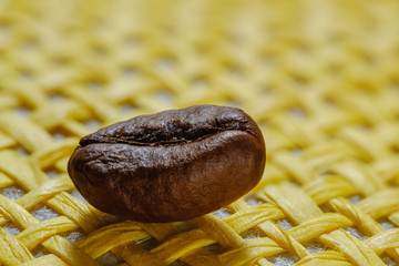 Set of fresh roasted macro coffee beans, yellow wicker basket background.