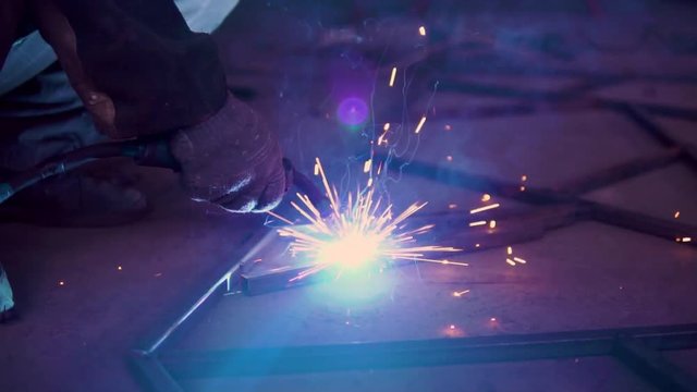 Close up of metal welding with sparks and smoke