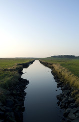 Fototapeta na wymiar Foehr / Germany: View over the salt marsh and the Godel rivulet near Witsum in the south of the island