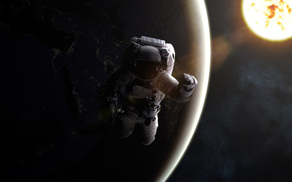 Astronaut in outer space. Sun and Earth. Image in 5K resolution for desktop wallpaper. Elements of the image are furnished by NASA
