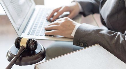Lawyer office. Judge gavel and hands of a lawyer working on a laptop. Legal law, advice and justice concept