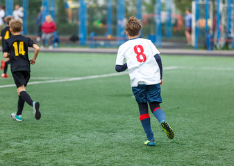 Obraz premium young boys play football, show dribbling, make passes to win on the summer spring field
