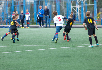 young boys play football, show dribbling, make passes to win on the summer spring  field