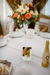 wedding decor on tables  in restaraunt, a bouquet of flowers with a glass vase