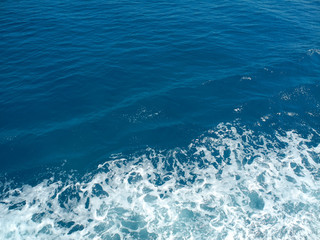 Fototapeta na wymiar Seafoam and deep blue sea