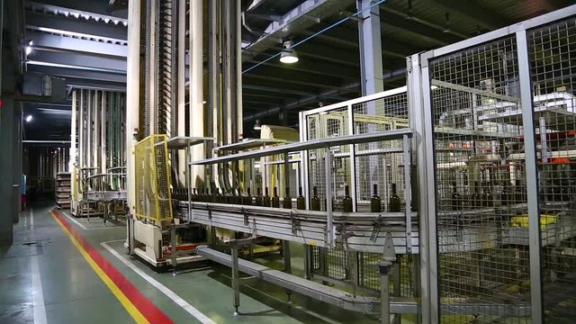 Wine bottles moving along a conveyor belt in a wine bottling factory. Bottle manufacturing technology in industrial factory. Glass recycling. Movement bottles. Production of glass bottles.