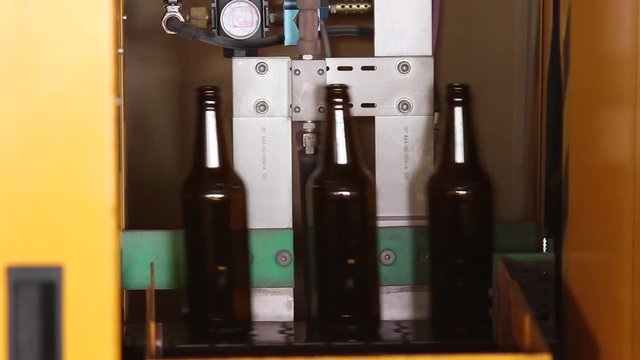 Beer bottle factory. Quality control of glass bottles. Glass bottle factory. Focus on bottles on a conveyor belt in a bottle. Transporter belt. Bottle production line.