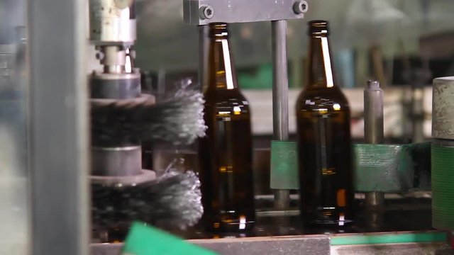 Bottles on conveyor line. Electronics checks the quality of the bottle on the glass factory. Quality control of glass bottles. Beer bottle factory. Rows of beer bottles in the factory. Close up.