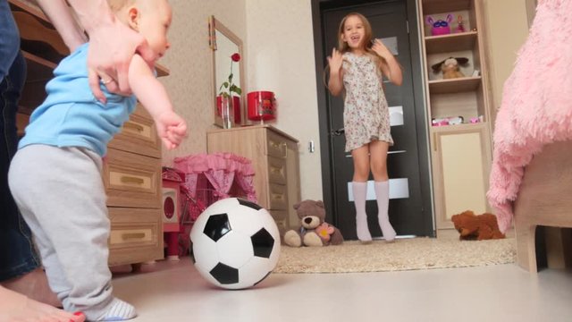 Mother and children in the room of the house playing with soccer ball
