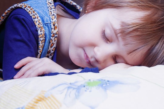 Bedtime. Happy and funny dreams of a little girl. Child girl relaxing in bed. (Sleep, health, happiness, childhood concept)