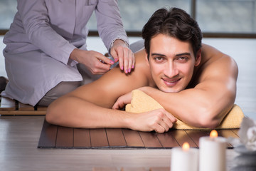 Obraz na płótnie Canvas Young handsome man during spa procedure