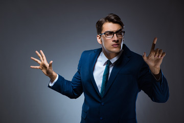 Businessman pressing virtual buttons on gray background