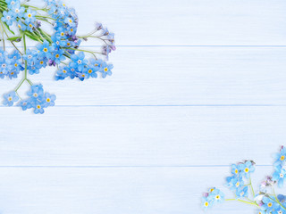 Blue forget-me-not flowers on the wooden planks background