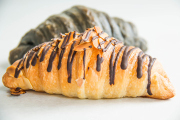 A chocolate croissant on white paper background