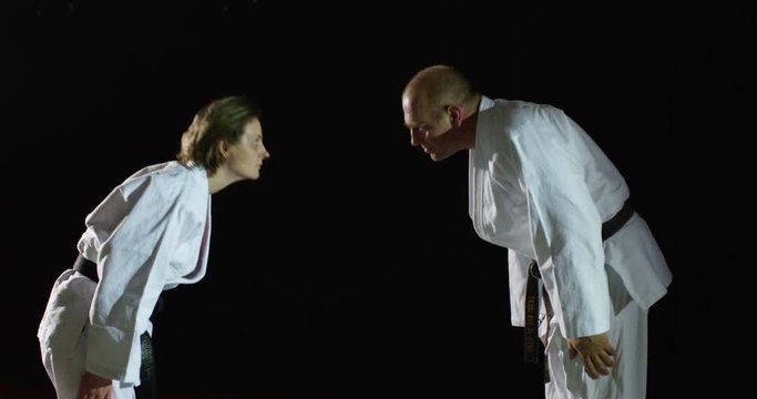 Two martial artists bow before their practicing in slow motion.