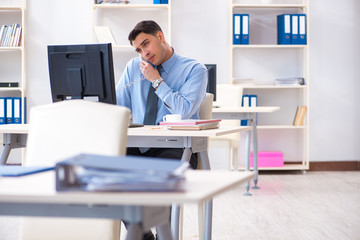 Handsome businessman employee sitting at his desk in office