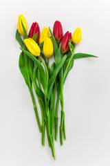 Bouquet of yellow and red tulips on white background.