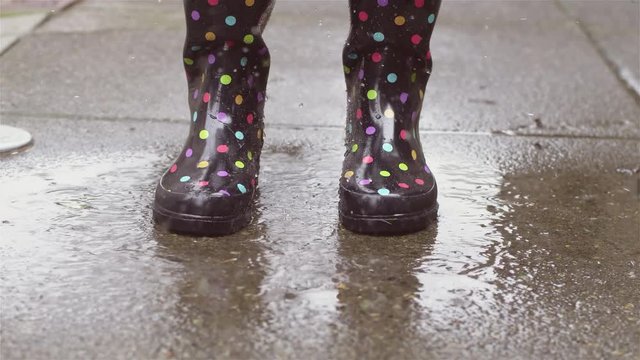 Close up shot of someone jumping on a puddle and splashing water in slow motion