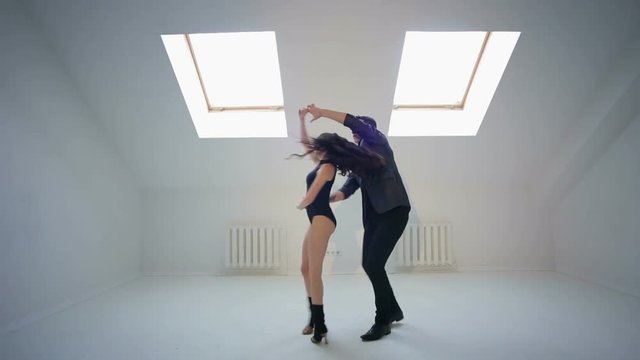Young couple dancing under Latin music. Bachata or merengue or salsa.