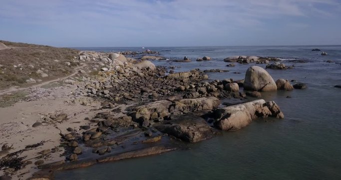 4K high quality aerial video footage of Western Cape's coast, Paternoster beach boulders, sandy sea front and Atlantic Ocean views in the background near Cape Town, South Africa on summer morning