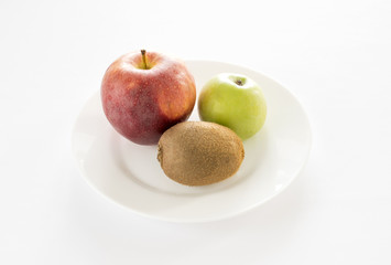 red apple, green apple, kiwi on a white plate