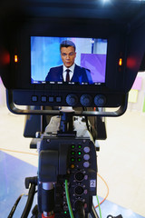 The news presenter reads the text on the teleprompter.Camera in the office. TV studio.