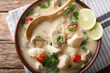 Thai chicken soup tom kha gai with coconut milk close-up in a bowl. horizontal top view from above