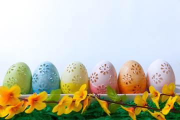 Easter, painted Easter eggs set in a bowl Easter decoration behind a white background