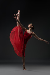 Slim girl dancing barefoot in the dark shot