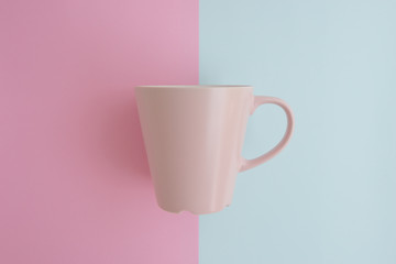 Minimal flat lay concept of pink coffee cup on the colorful background with copy space