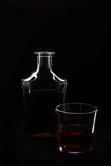 Glass of whiskey with bottle.