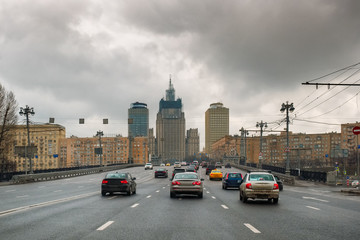 Fototapeta na wymiar Traffic in a rainy spring Moscow. Dark stormy clouds. Contrasting sky. Dirty cars on the road