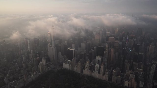 New York City aerial view of Manhattan skyline at sunrise from Central Park with fog and low level clouds over Midtown and Times Square.