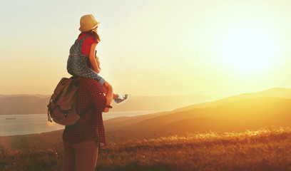 family travel and tourism father and daughter   on top of mountain at sunset.