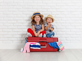 happy laughing children  with suitcase going on a trip