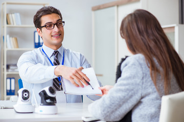 Sales assistant showing cameras to client in shop